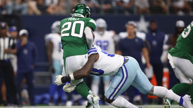 Jets' RB Breece Hall (20) stopped by Cowboys' DE DeMarcus Lawrence (90)